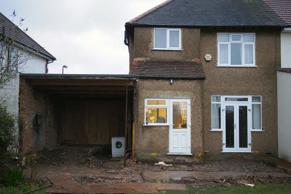 Voor: achterkant van de woning met een open carport