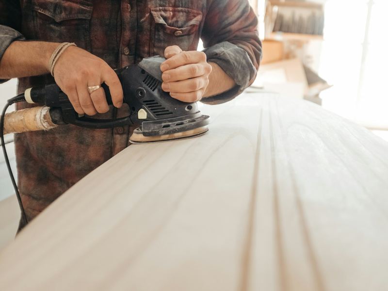 Vakman schuurt een houten werkblad glad