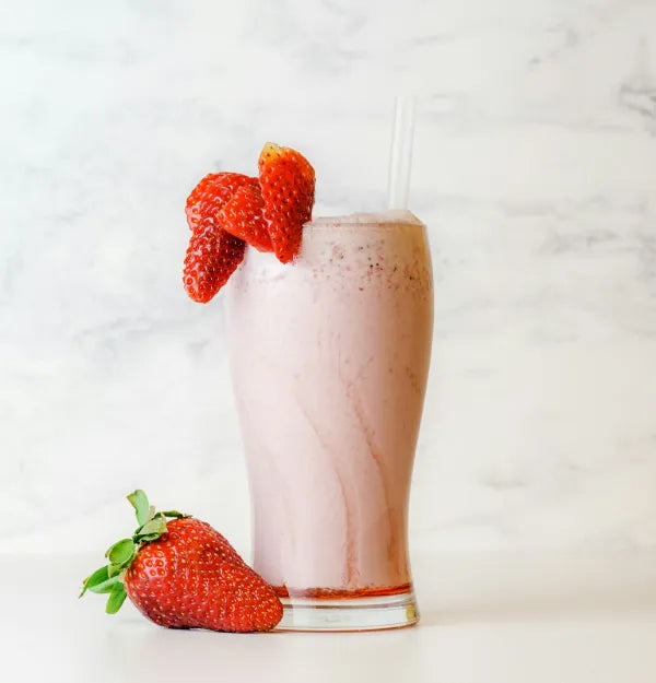 Roze aardbeienshake in een hoog glas met aardbeien