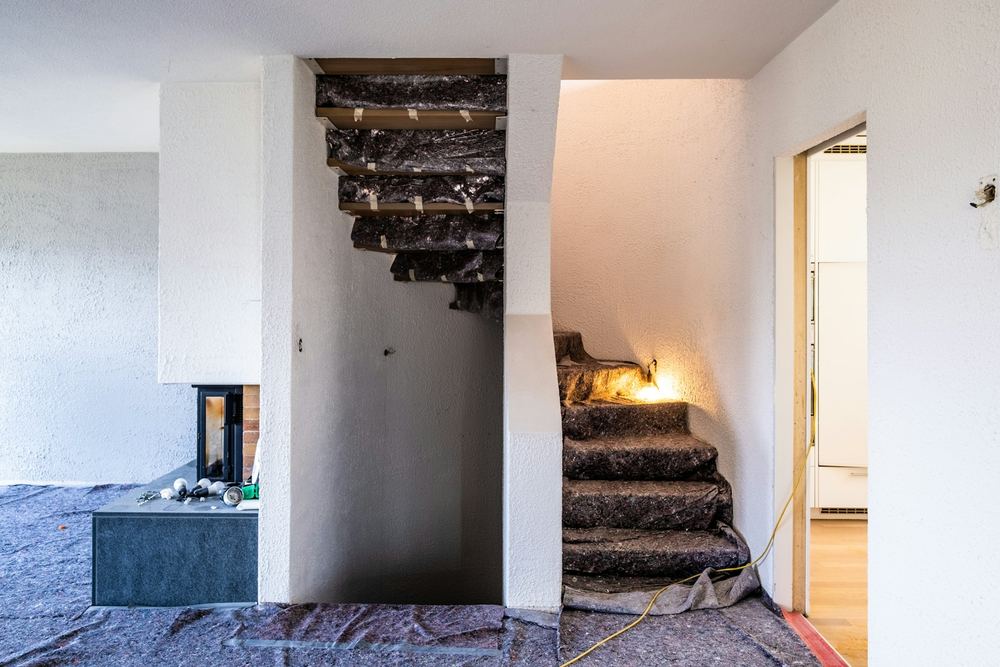 Tijdens: trap afgedekt met stucloper, vloer met beschermfolie