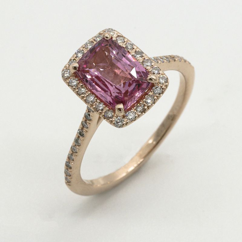 Roségouden ring met een rechthoekige roze steen, omringd door kleine diamanten