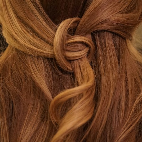 Koperkleurig haar met een losse knoop op het achterhoofd