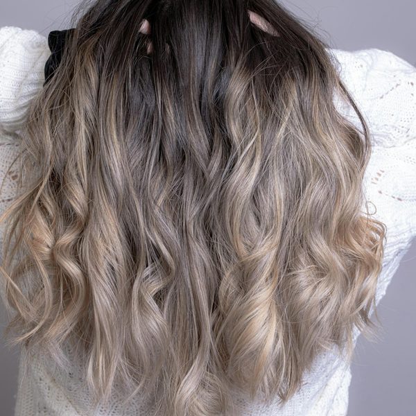 Lang golvend haar met een zachte balayage van donker naar asblond