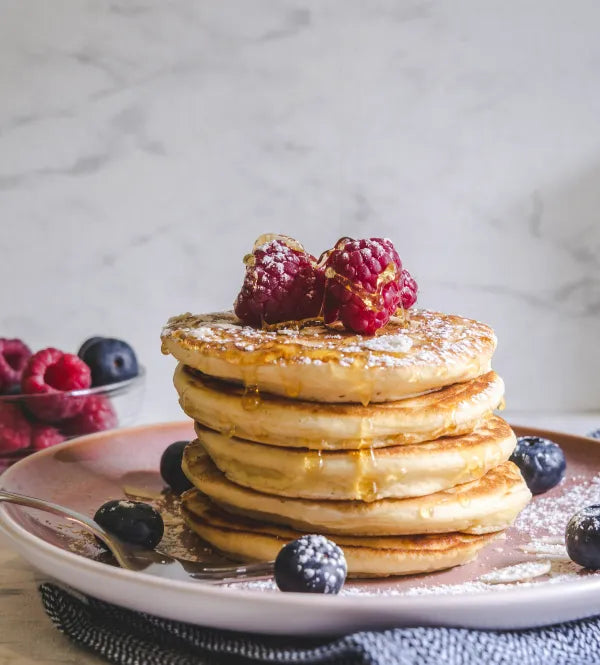 Stapel pannenkoeken met frambozen en blauwe bessen